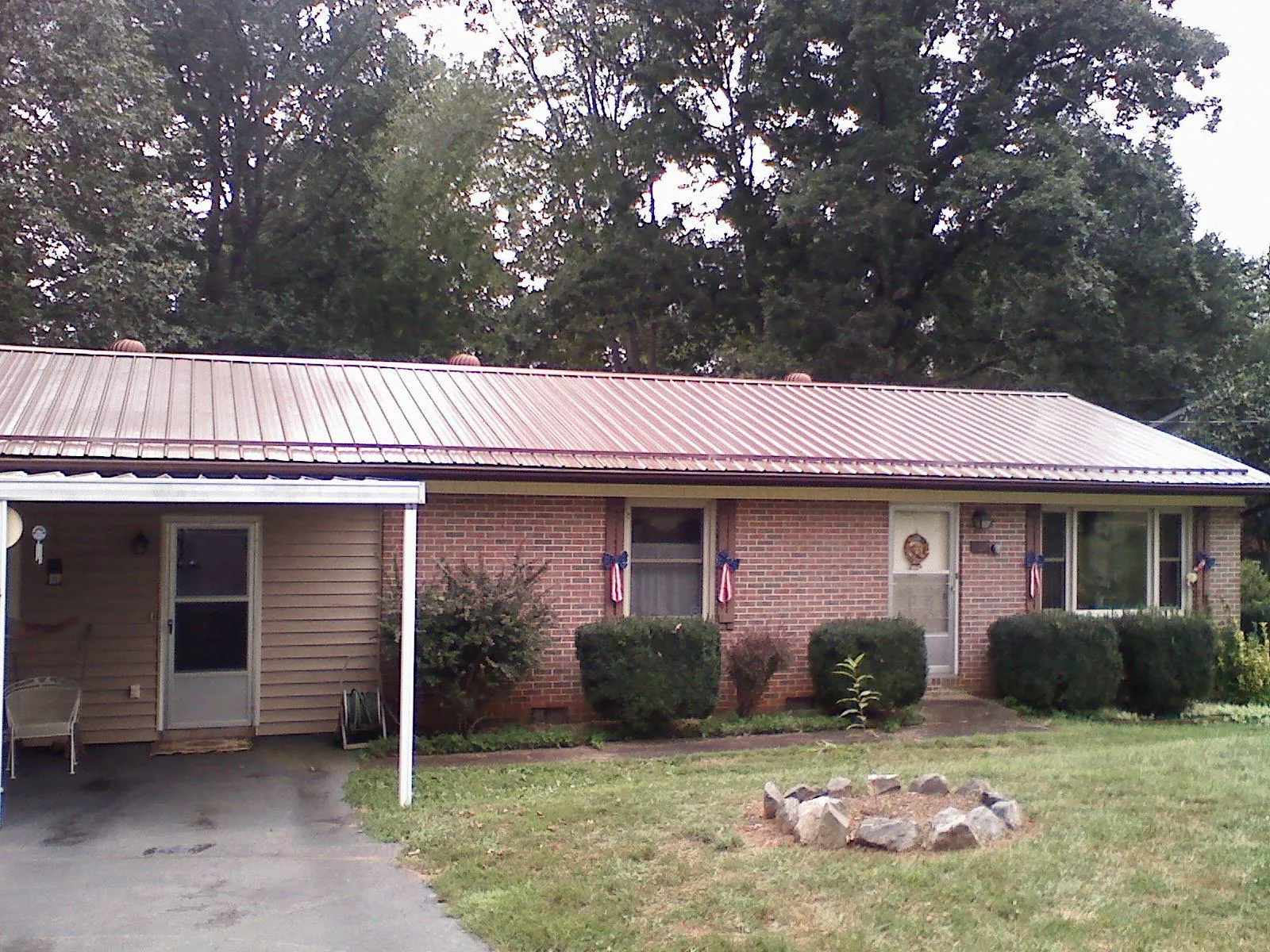 Bronze metal roof and carport on a brick ranch home — Roof Repair work by our crew in Holt